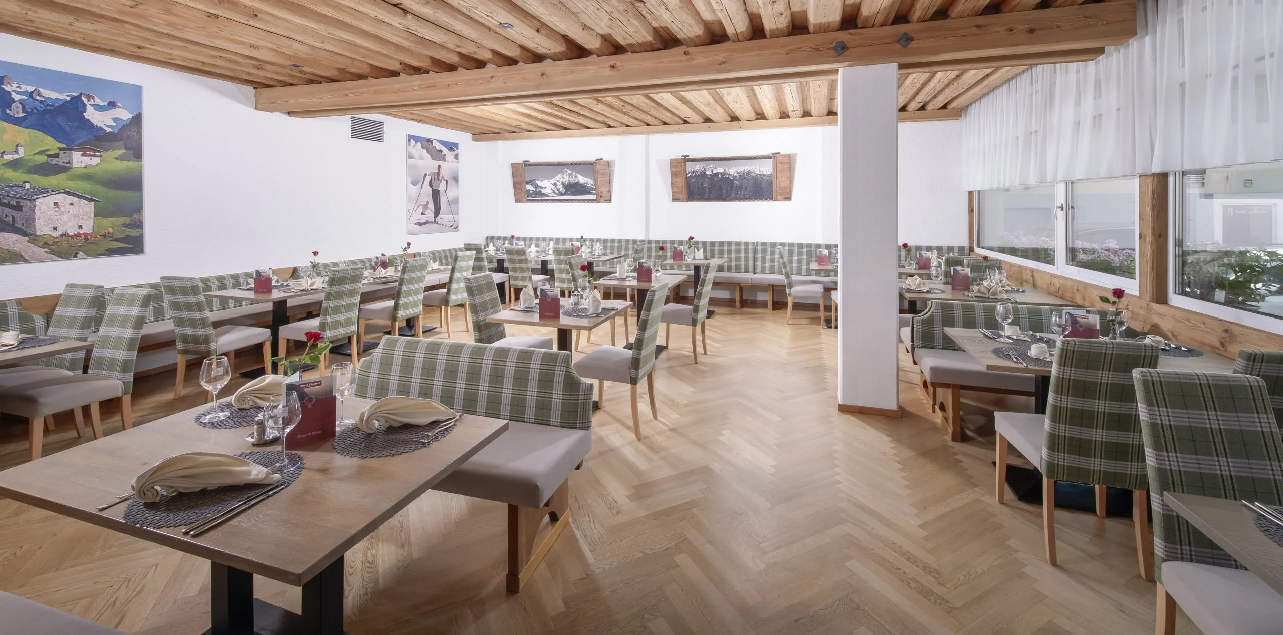 Speisesaal mit Holzbalkendecke und eleganten Tischen