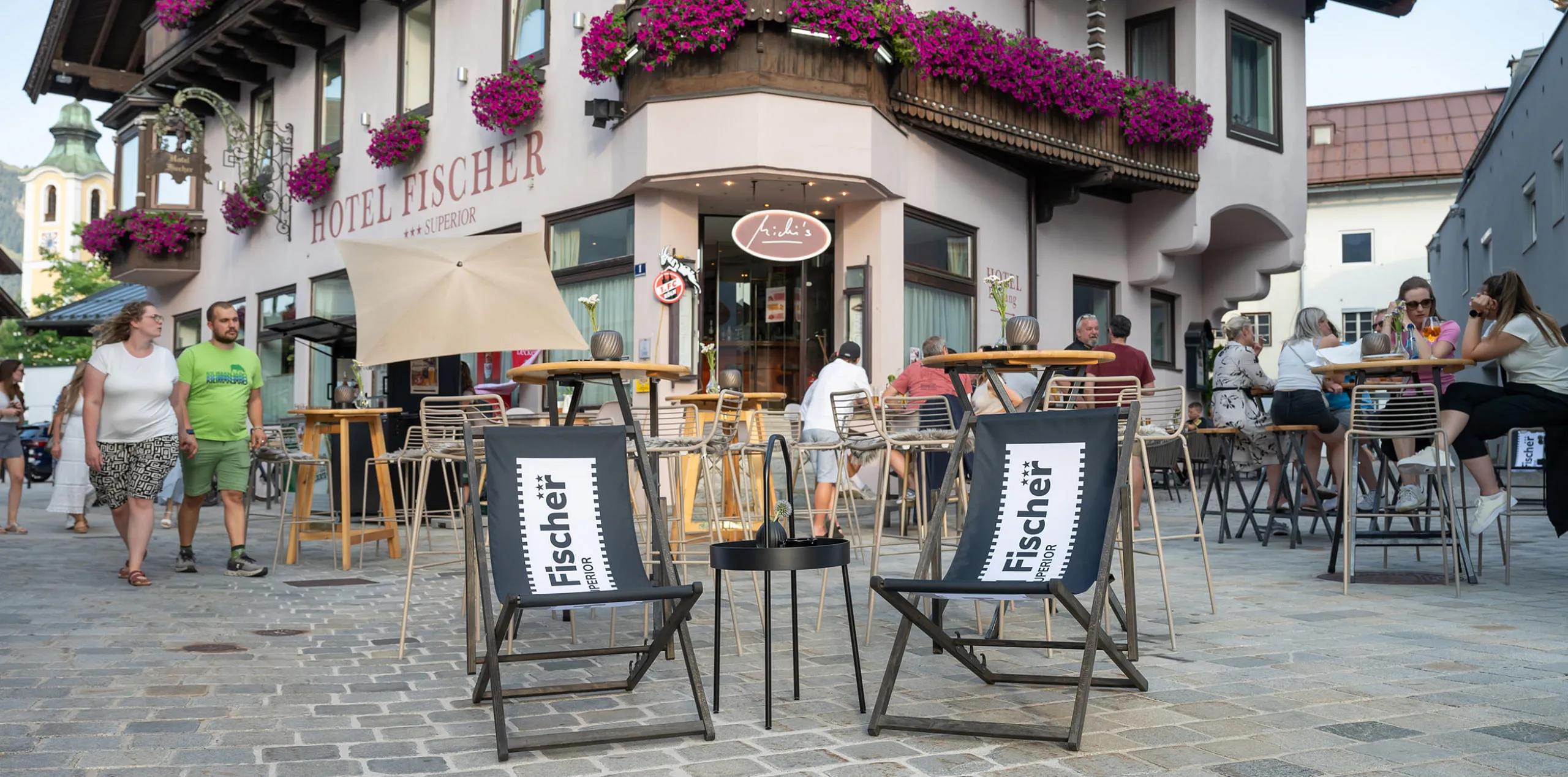Liegestühle vor dem Hotel Fischer mit bunter Blumenpracht