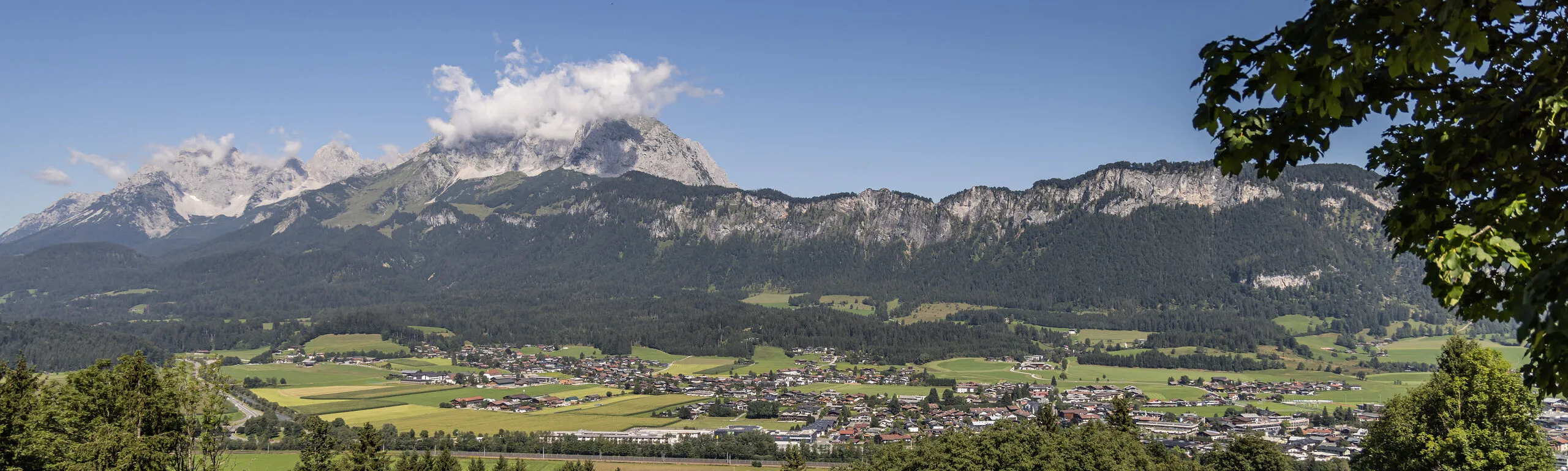 Blick über das Tal von St. Johann in Tirol auf den Wilden Kaiser im Sommer