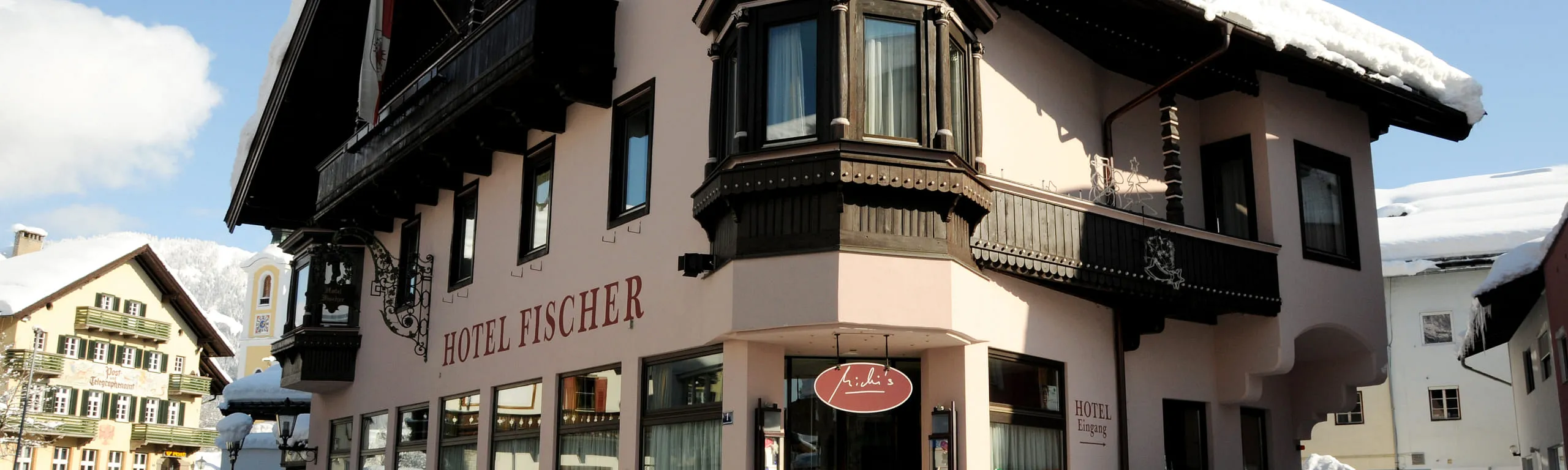 Hotel Fischer im Winter, Eckansicht des verschneiten Hauses im Ortszentrum